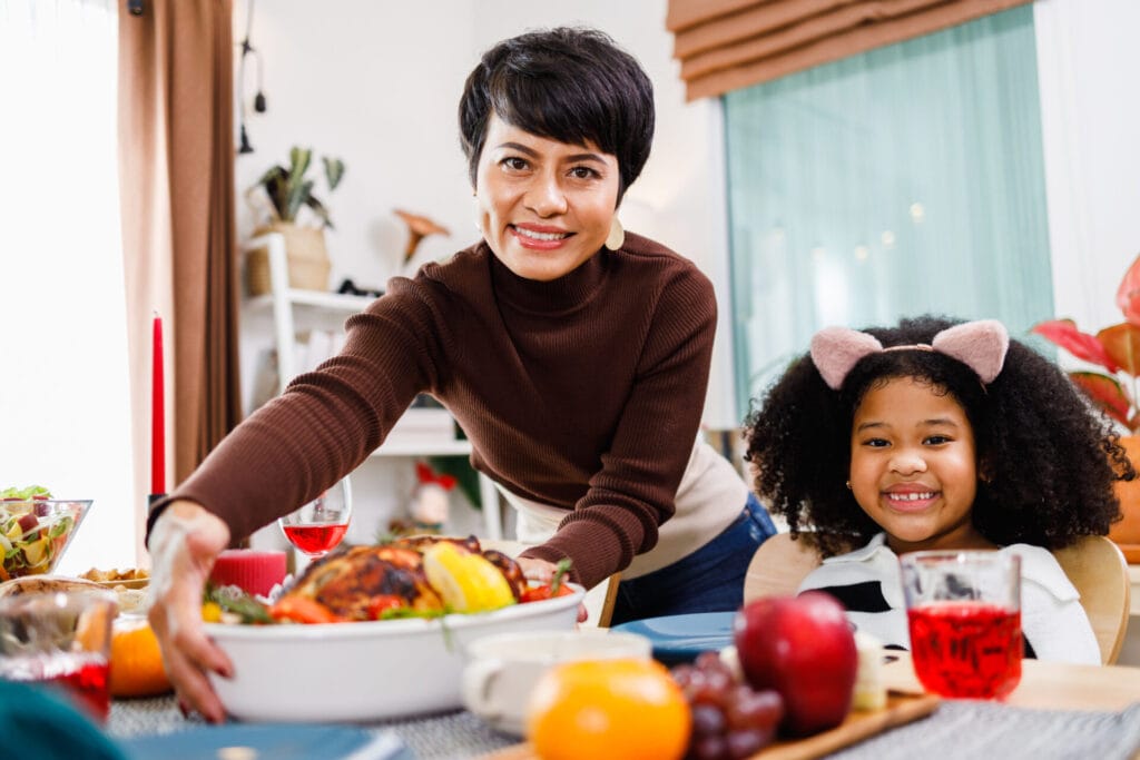Happy family are having dinner at home. Celebration holiday and togetherness serving festive Turkey meal.