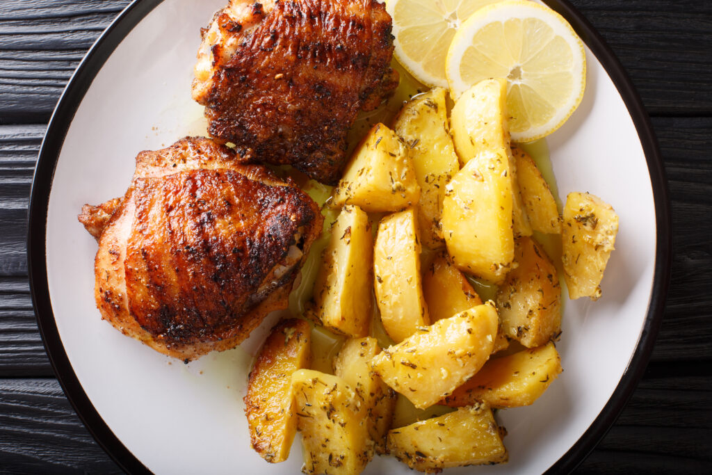 A plate of food with lemon slices and chicken.