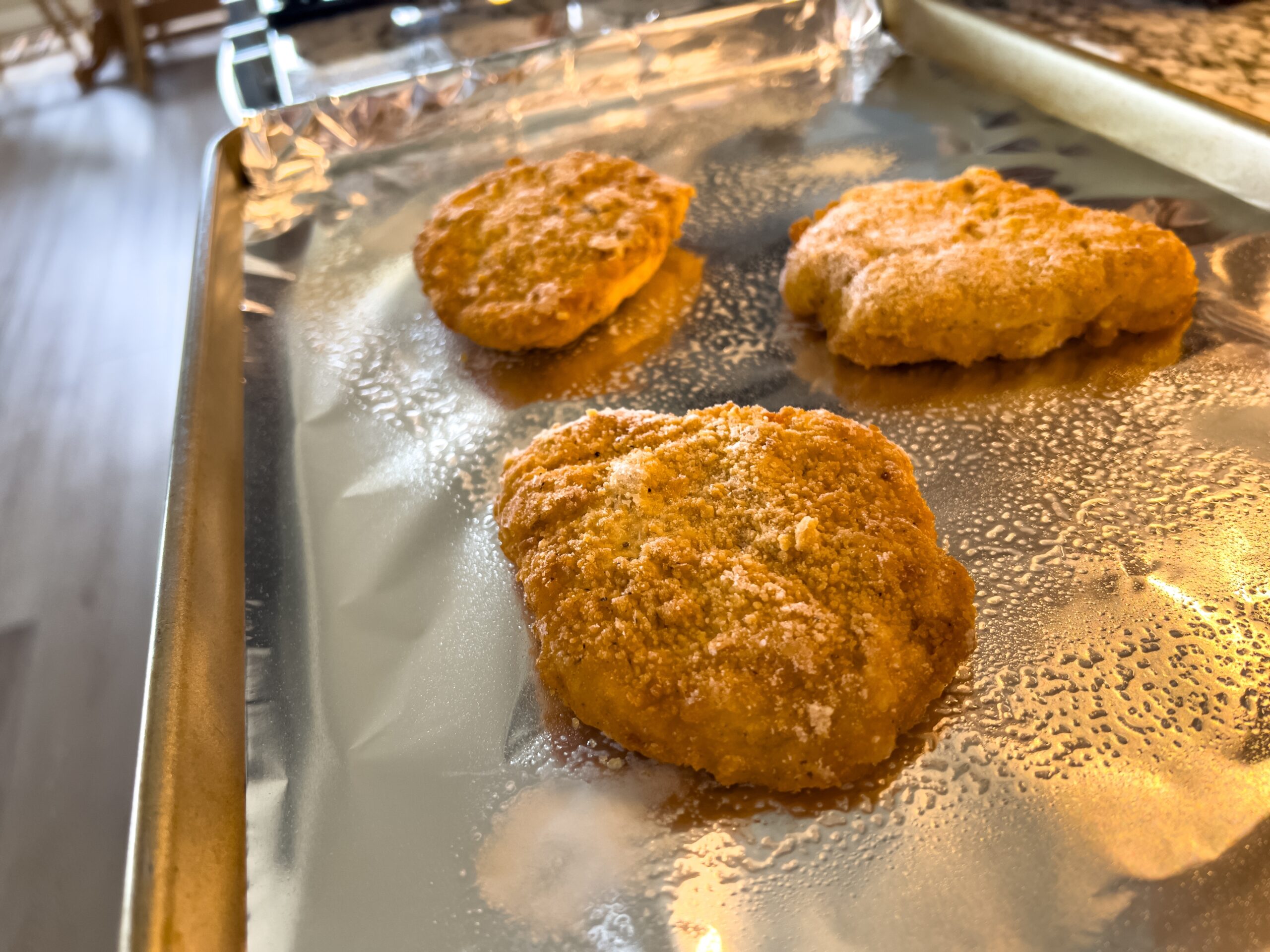 Three golden-brown chicken nuggets on tray